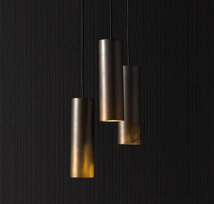 Three metal hanging lights mounted on a black wall, showcasing the craftsmanship of Artisan Lighting Company.