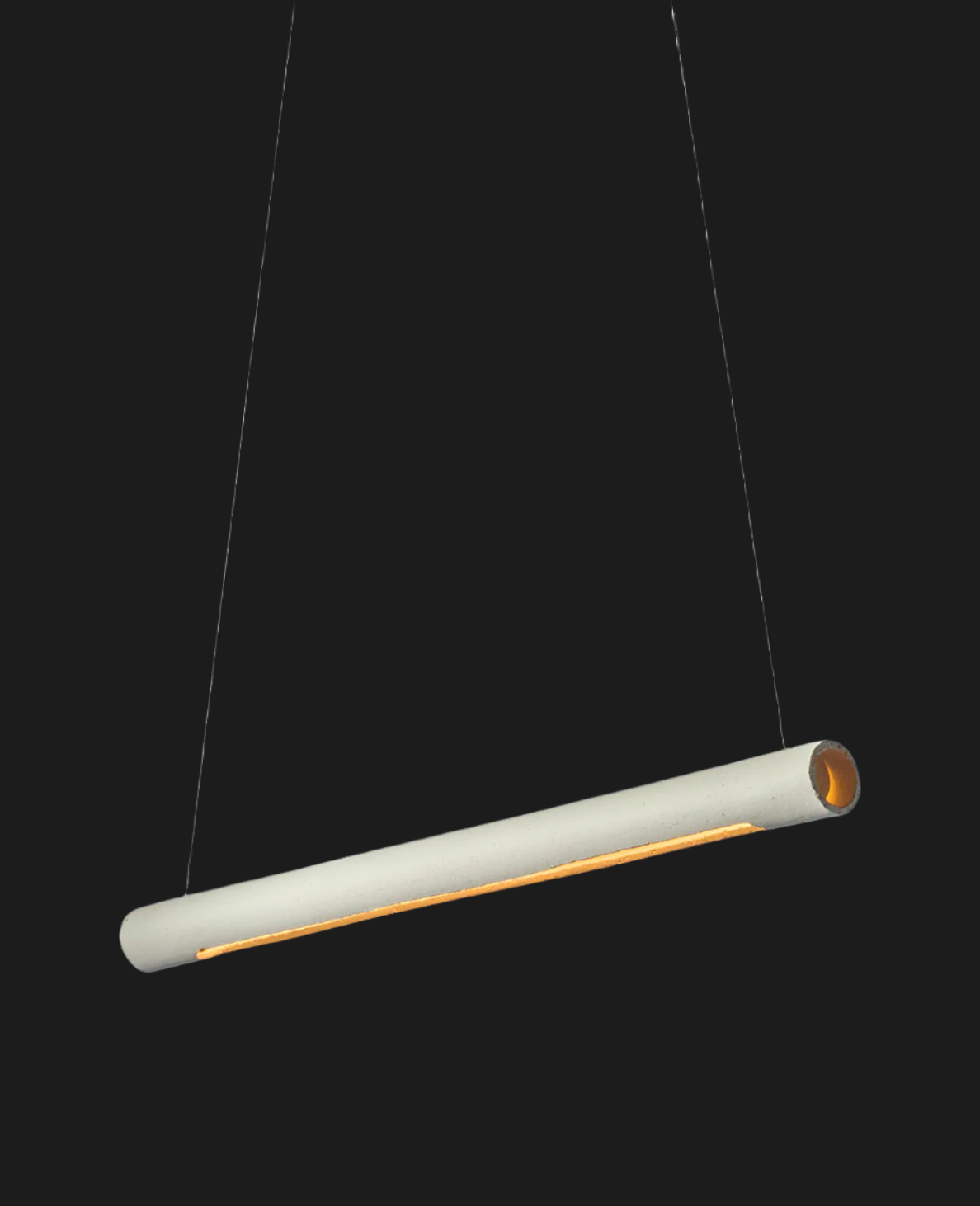 white ceramic tube shaped lighting fixture illuminated on black background