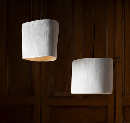 Handmade pendant lights hanging in a warm, refined interior