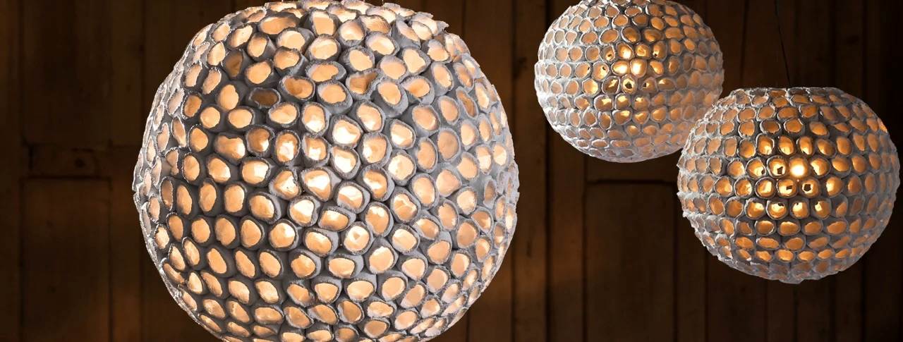 Handmade mosaic glass pendant lights with spherical design, casting warm textured ambient illumination.