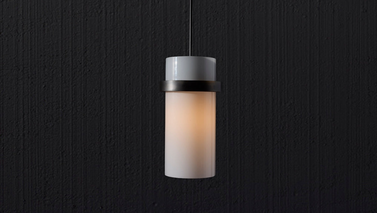 Handmade cylindrical pendant light with frosted glass shade and metal accent, offering warm modern illumination.
