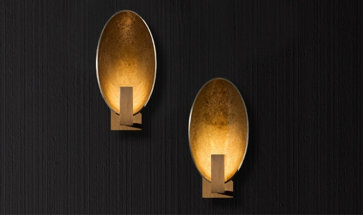 Italian oval wall sconces in brushed gold finish, creating warm ambient lighting for refined interiors.