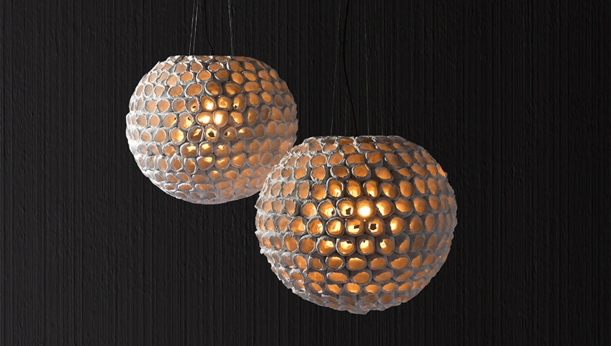 Artisanal Italian spherical pendant lights with textured mosaic glass, emitting warm ambient glow for luxury interiors.