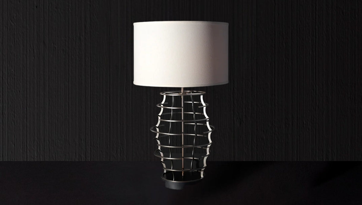 Modern Italian table lamp with sculptural metal base and white fabric shade, designed for refined ambient lighting.