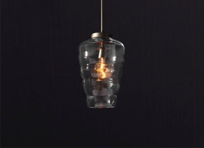 Glass pendant light with exposed filament creating warm ambient glow