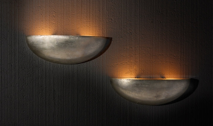Minimalist wall sconces casting warm ambient light on textured walls
