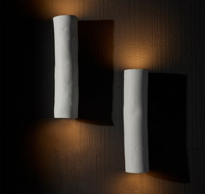 Modern luxury wall sconces with sculptural white finish, casting warm indirect light for elegant Dallas interiors.
