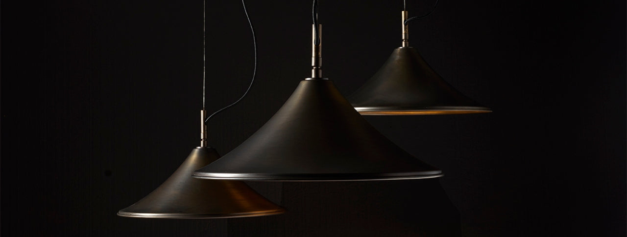 Luxury metal pendant lights with sleek conical design and warm interior glow, ideal for modern Dallas interiors.