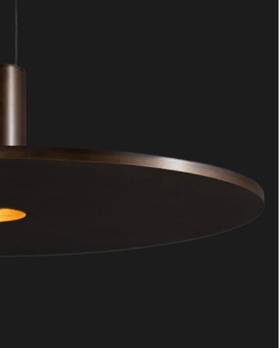 metal disk lighting fixture illuminated on black background