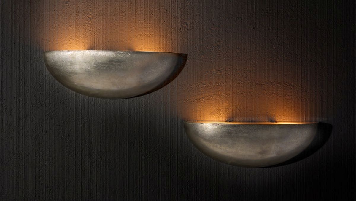 Artisan Lighting Company presents two wall sconces, each glowing softly, enhancing the ambiance of the space.