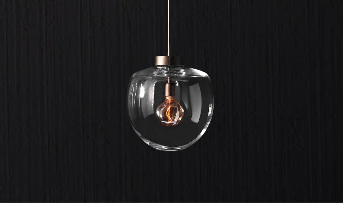 Handcrafted glass pendant with exposed bulb showcasing a modern bespoke lighting design.