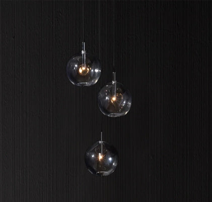 Three suspended glass globe pendants showcasing a modern bespoke lighting installation.