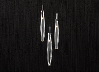 Three elongated crystal pendant lights from a bespoke lighting collection.