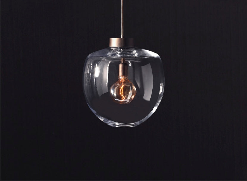 Modern luxury glass globe pendant with exposed filament bulb, perfect for contemporary Dallas interiors.