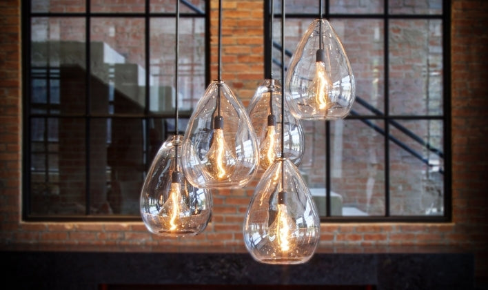 Statement glass teardrop pendant lights with exposed filament bulbs, creating a dramatic focal point in luxury home interiors.