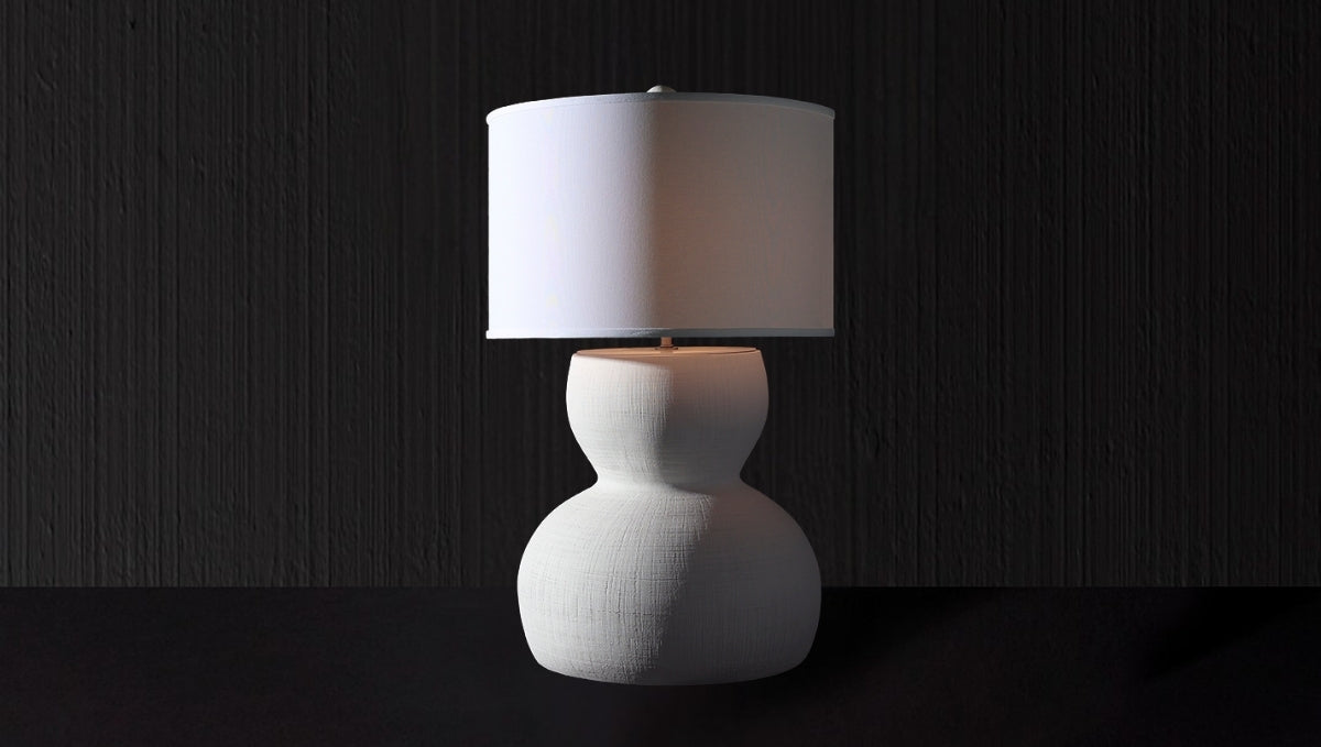 Sculptural ceramic table lamp with rounded silhouette and white drum shade, perfect for luxury home interiors.